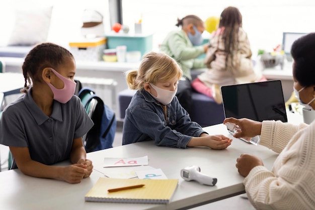 Female teacher teaching kids about disinfecting