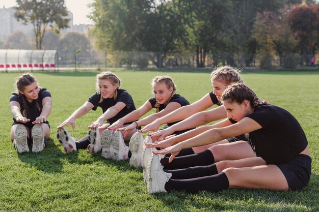 Female team doing warming up exercises