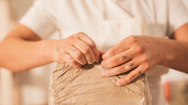 Female tearing off the cover of the clay