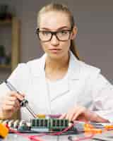 Free photo female technician with electronics board and soldering iron