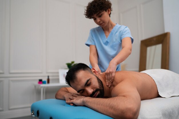 Female therapist in the rehabilitation center giving back massage