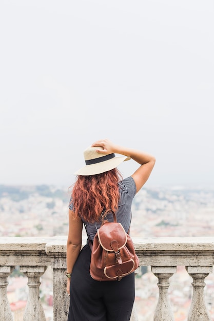 Free photo female tourist on balcony from behind