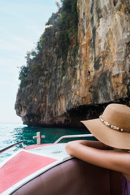 Free photo female tourist leaning on boat travel near the cliff