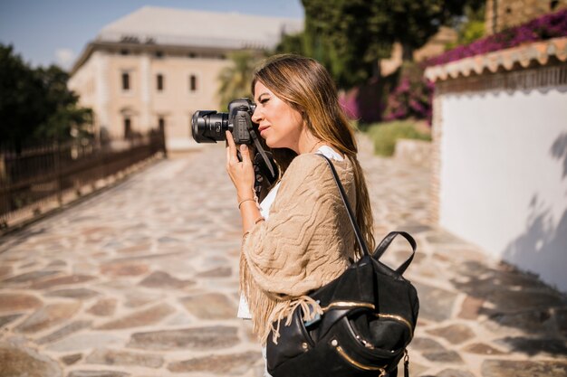 Female tourist taking photograph on camera