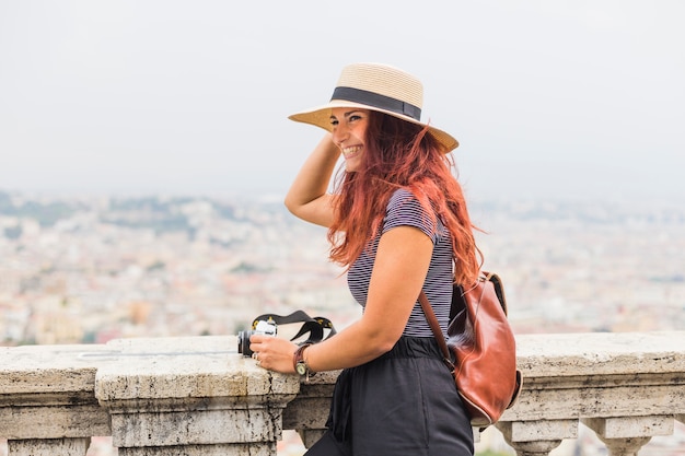 Free Photo female tourist with camera on balcony