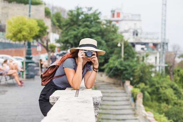 Female tourist with camera on balcony