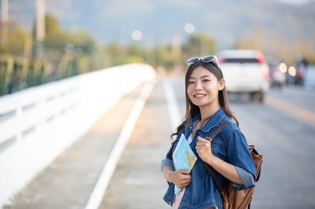 Female tourists on hand have a happy travel map.