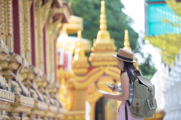 Female tourists hold a map to find places.