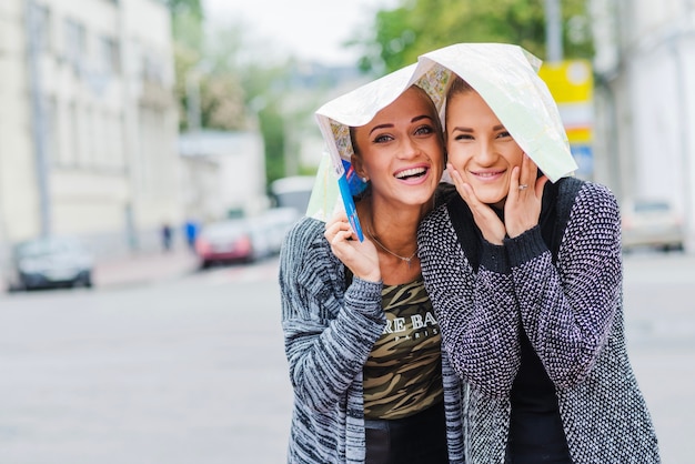 Female tourists with map on head