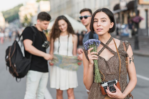 Female traveler with flowers and camera