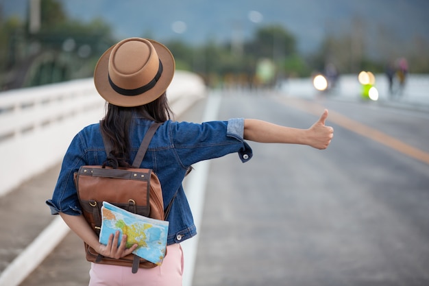 Female travelers waving cars on the road