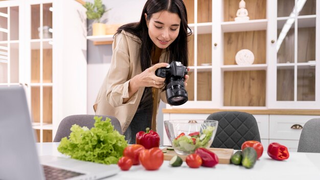 Female vlogger at home taking pictures with camera