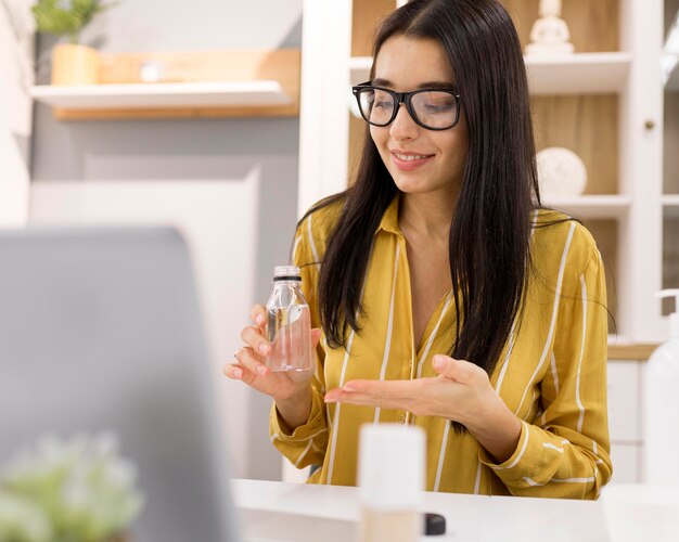 Female vlogger at home with products and laptop