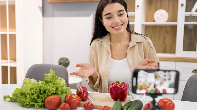 Female vlogging at home with vegetables