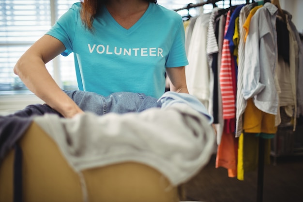 Female volunteer holding clothes in donation box