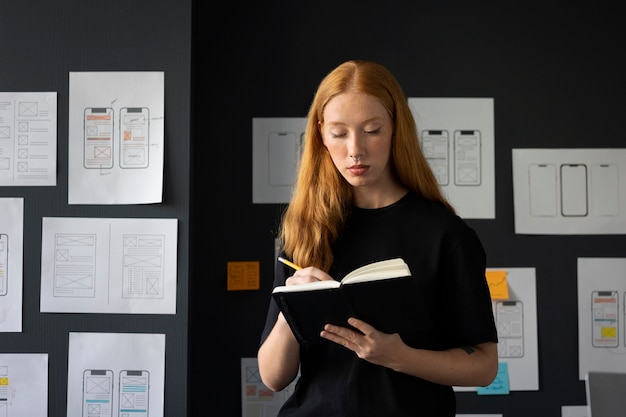 Free photo female web designer in the office with notebook