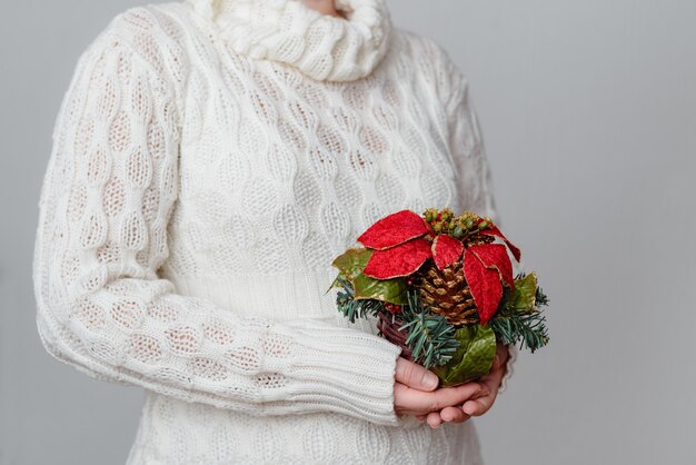 Female in a white sweater holding a Christmas ornament