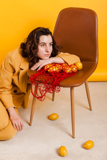 Free photo female with lemons on chair