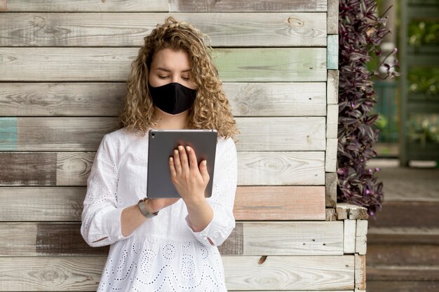 Female with mask using tablet