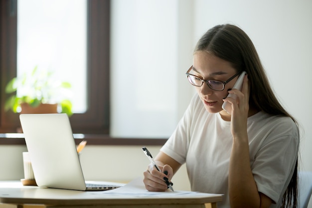 Female worker consulting client over phone