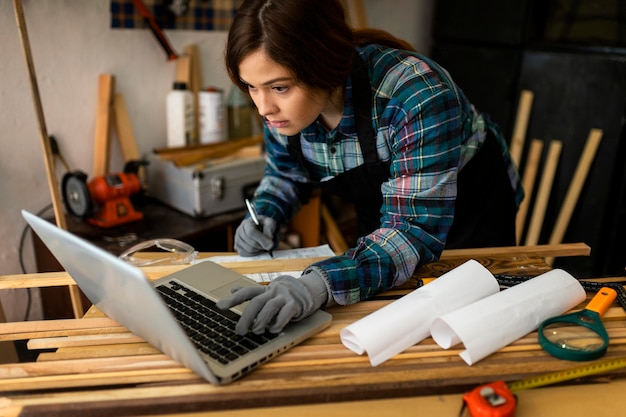 Free Photo female working in workshop and using laptop