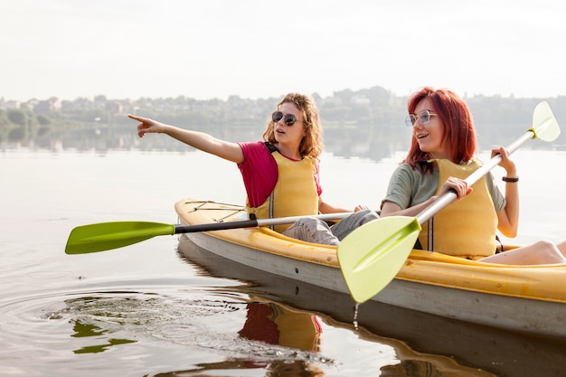 Free photo females rowing in kayak on lake