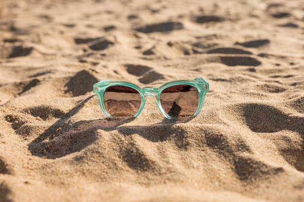 Free photo feminine sunglasses on sand