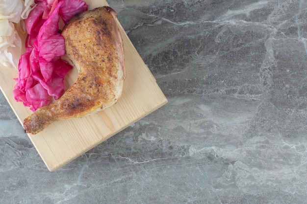 Free Photo fermented cabbage with grilled chicken on wooden board. 