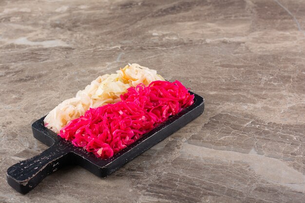 Fermented vegetables sauerkraut placed on stone table.