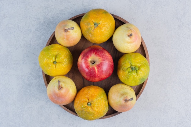 Fersh organic fruits on Wooden board. Tangerine, red apple and pear. 