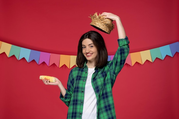 Festa junina lovely cute girl wearing straw hat celebrating brazilian festival holding corn happy