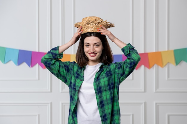 Free photo festa junina pretty young girl taking straw hat celebrating off brazilian party