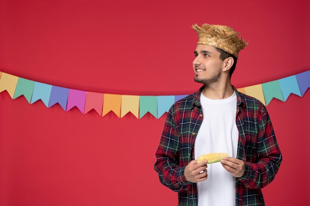 Free photo festa junina smiling cute guy wearing straw hat celebrating brazilian festival looking up