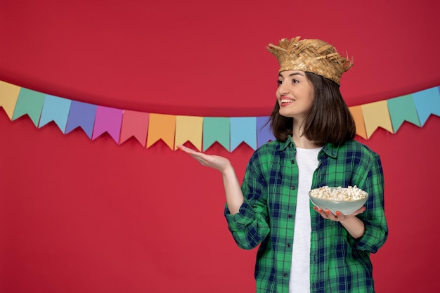 Festa junina young cute girl in green shirt celebrating brazilian festival holding popcorn