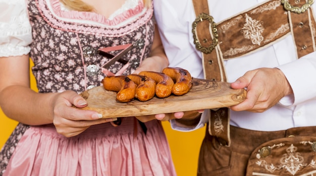 Free photo festival friends holding traditional bratwurst