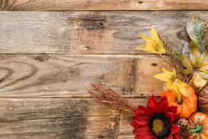 Free photo festive autumn decor of pumpkins flowers and leaves on a wooden background