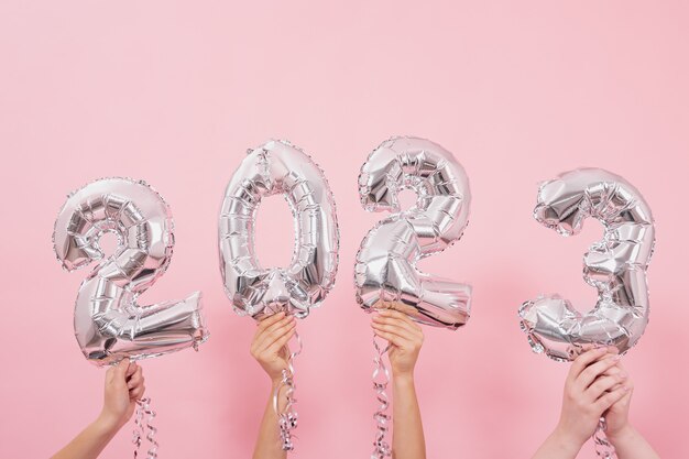 Festive balloons in from the numbers  on a pink background