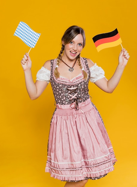 Free photo festive bavarian girl holding flags