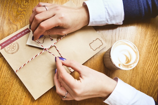 Free Photo festive decoration with women's hands new year's letter in an envelope and a glass 