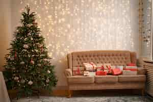 Free photo festive interior with many presents on comfortable sofa and decorated christmas tree