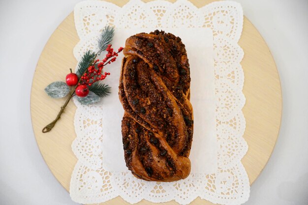 Free photo festive rustic romanian sweet bread with cinnamon a christmas branch on the side