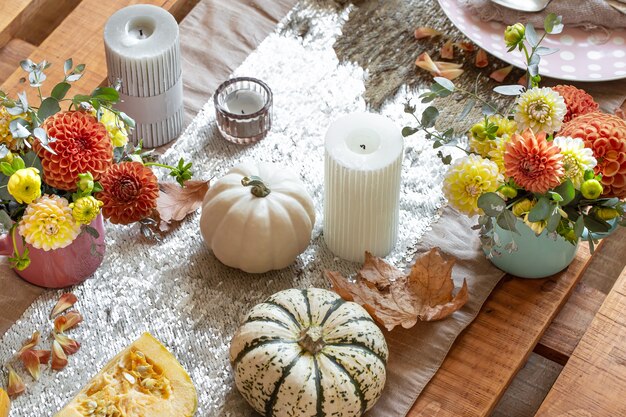 Festive table setting with pumpkins candles and chrysanthemum flowers