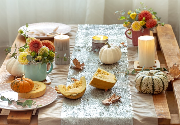 Festive table setting with pumpkins and chrysanthemum flowers