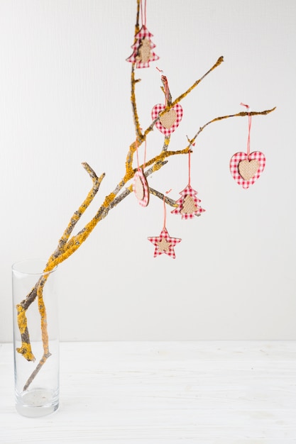 Festive tree branch decorated with ornaments 