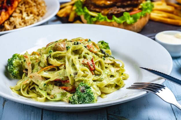 Fettuccine pasta broccoli chicken creamy sauce spices pepper side view