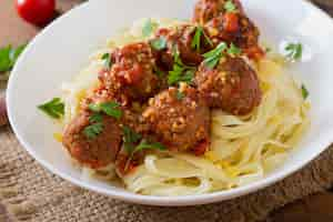 Free photo fettuccine pasta with meatballs in tomato sauce