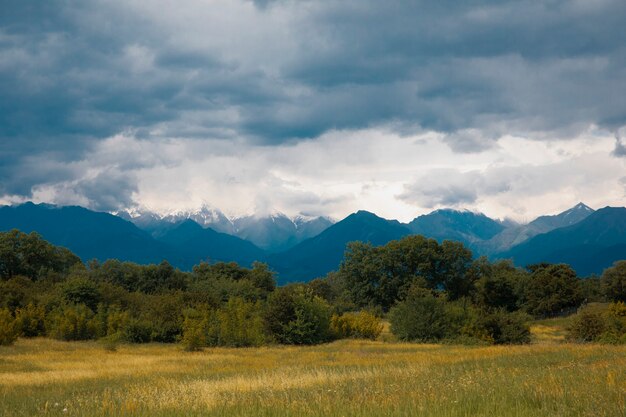 Fields across mountains under the cloudy weather