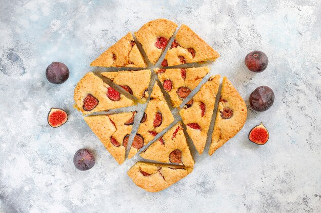 Fig cake with fresh figs on grey concrete table.