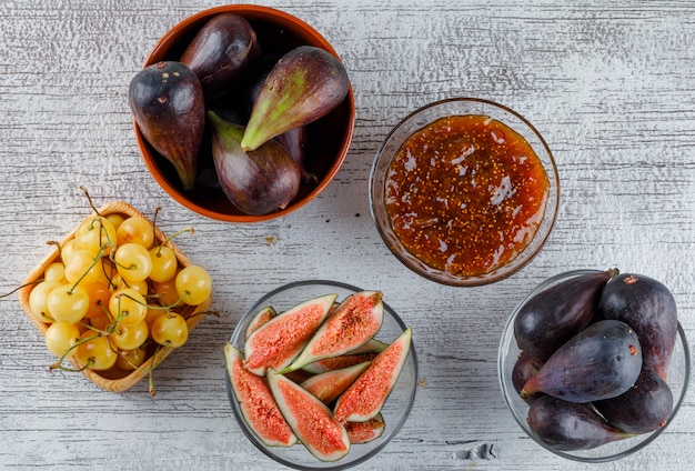 Fig jam in a bowl with figs, cherries flat lay on a grungy