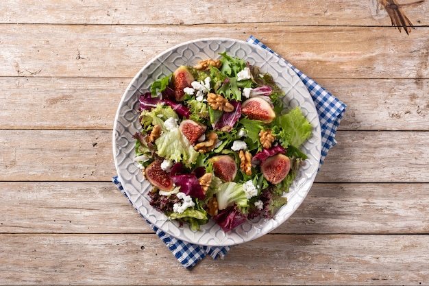 Free photo figs salad with cheese and walnuts on wooden table.